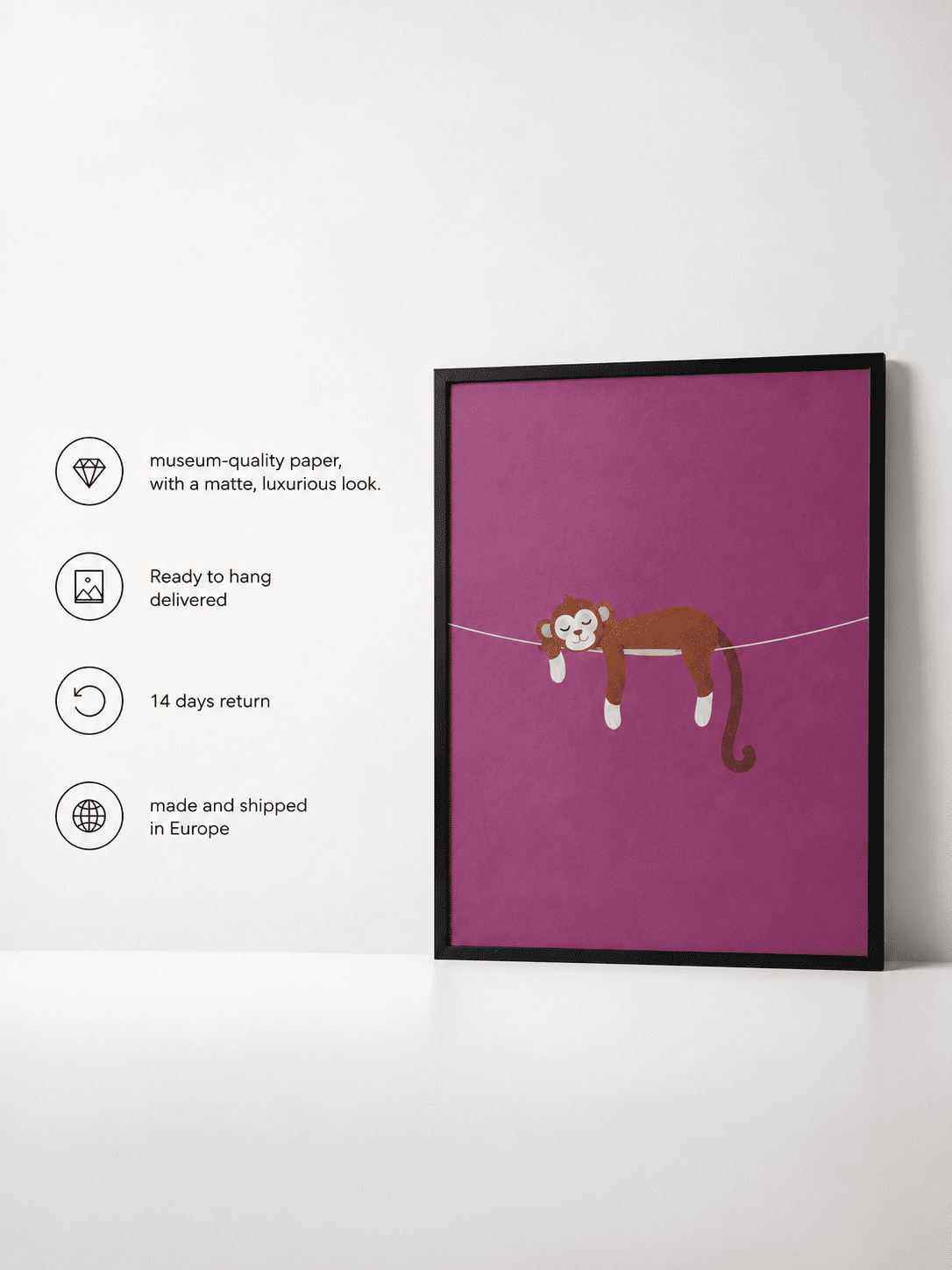 A framed art print featuring a brown cartoon monkey hanging on a wire against a magenta-purple background, displayed on a white surface against a white wall. To the left are four feature callouts with icons and text about museum-quality paper, ready-to-hang delivery, 14-day return, and European shipping.